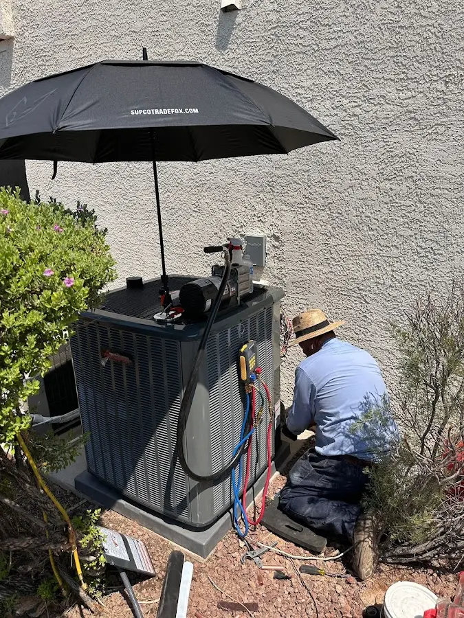 HVAC technician performing outdoor AC maintenance in Kanab